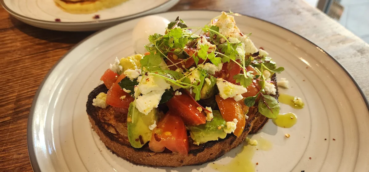 Ox Heart Tomato with Goat Cheese Feta on Sourdough Bread with Poached Egg