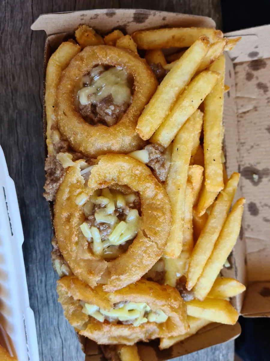 Smoked Beef Pie Mixture Slopped on Chips with Cheese and 3 Onion Rings to Garnish