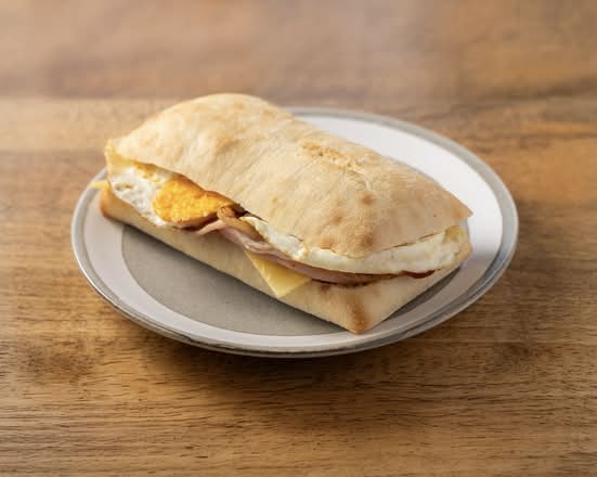 Egg, bacon and cheese panini roll with tomato relish